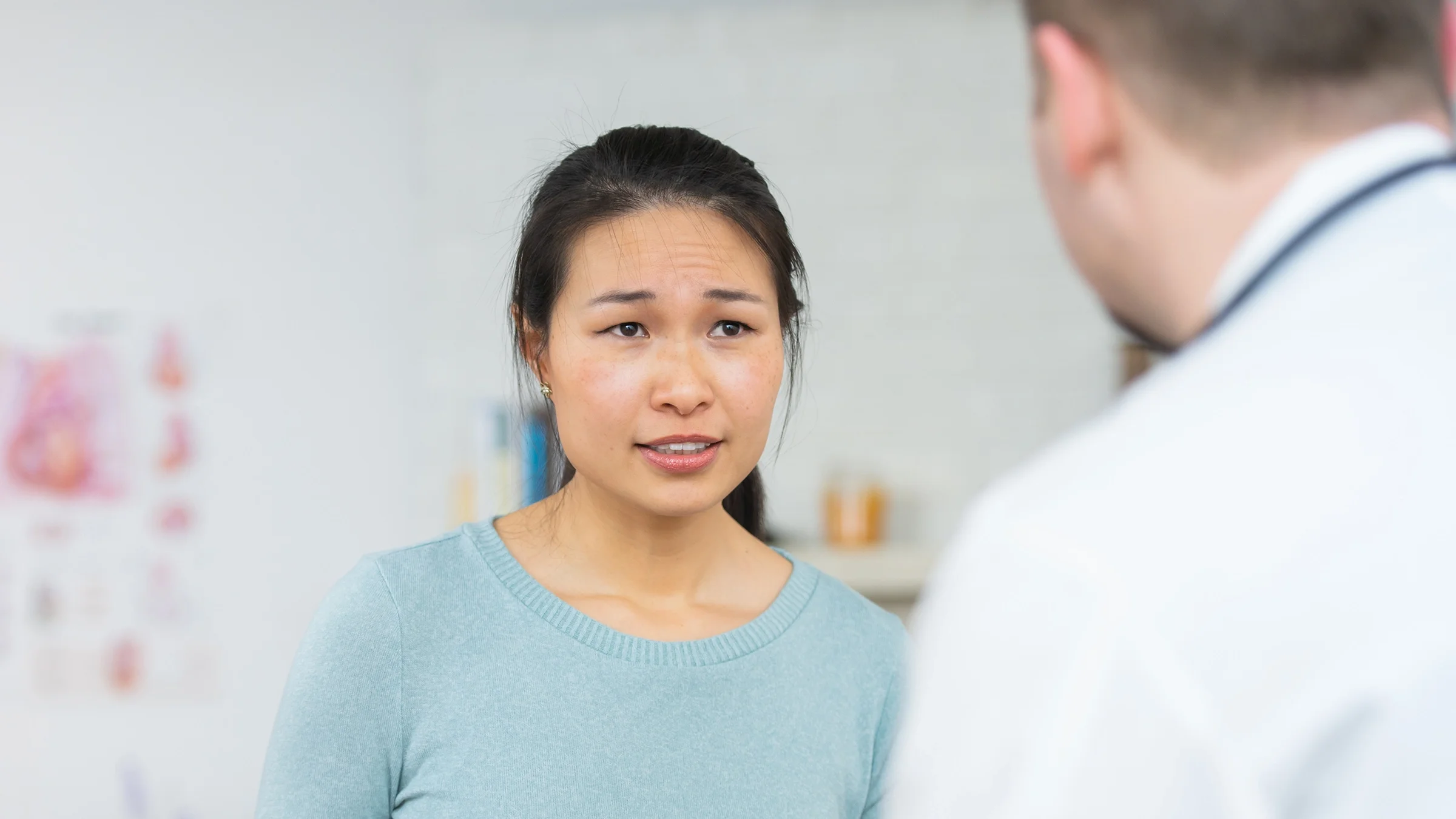 A woman talks with a healthcare professional during a medical appointment. 
