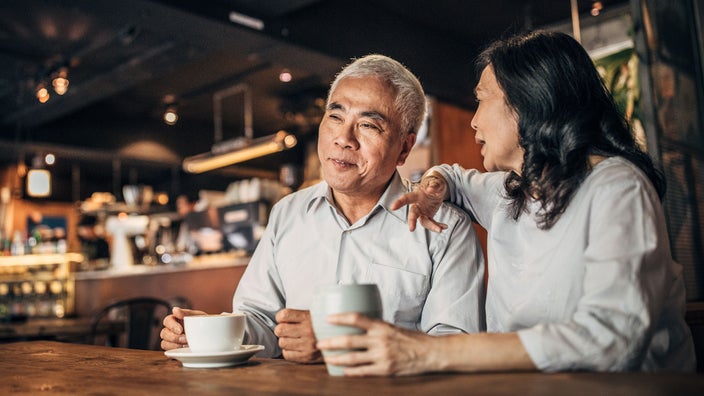 An older couple drinks coffee in a cafe. Coffee may lower the risk of Parkinson’s disease in some people.