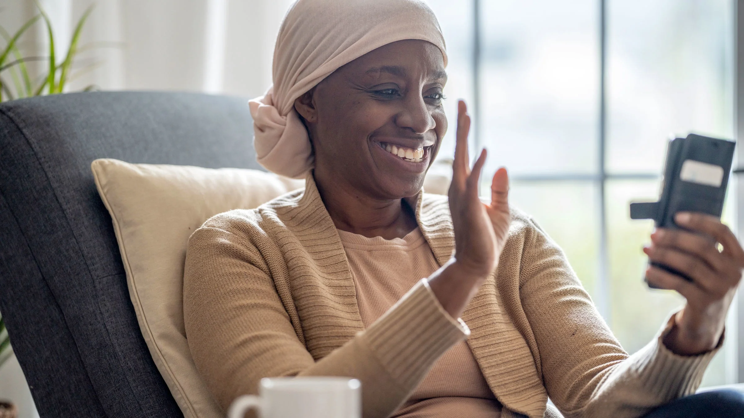 Woman with headscarf video calls on smartphone