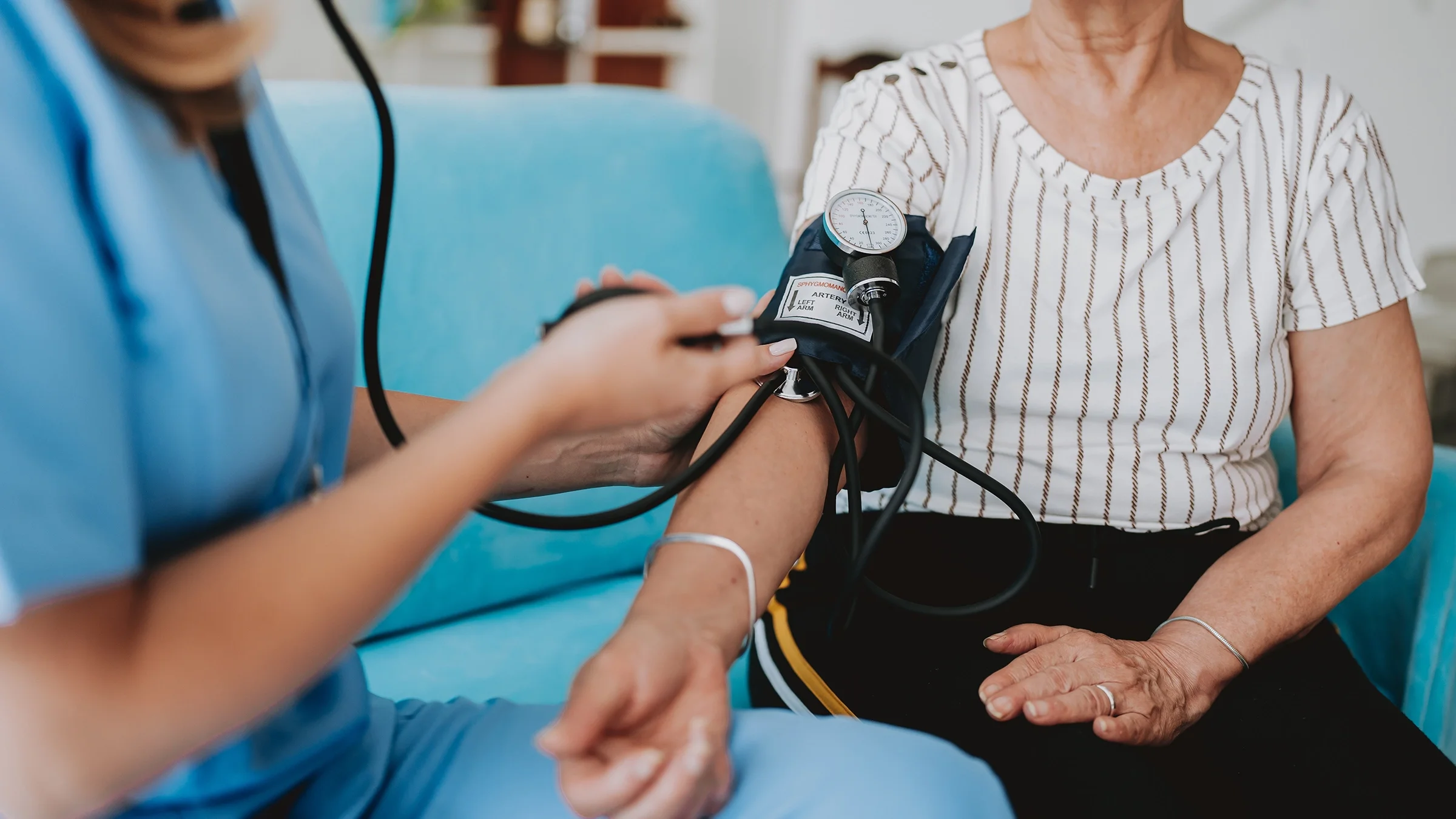 A woman is having her blood pressure measured at a clinic.