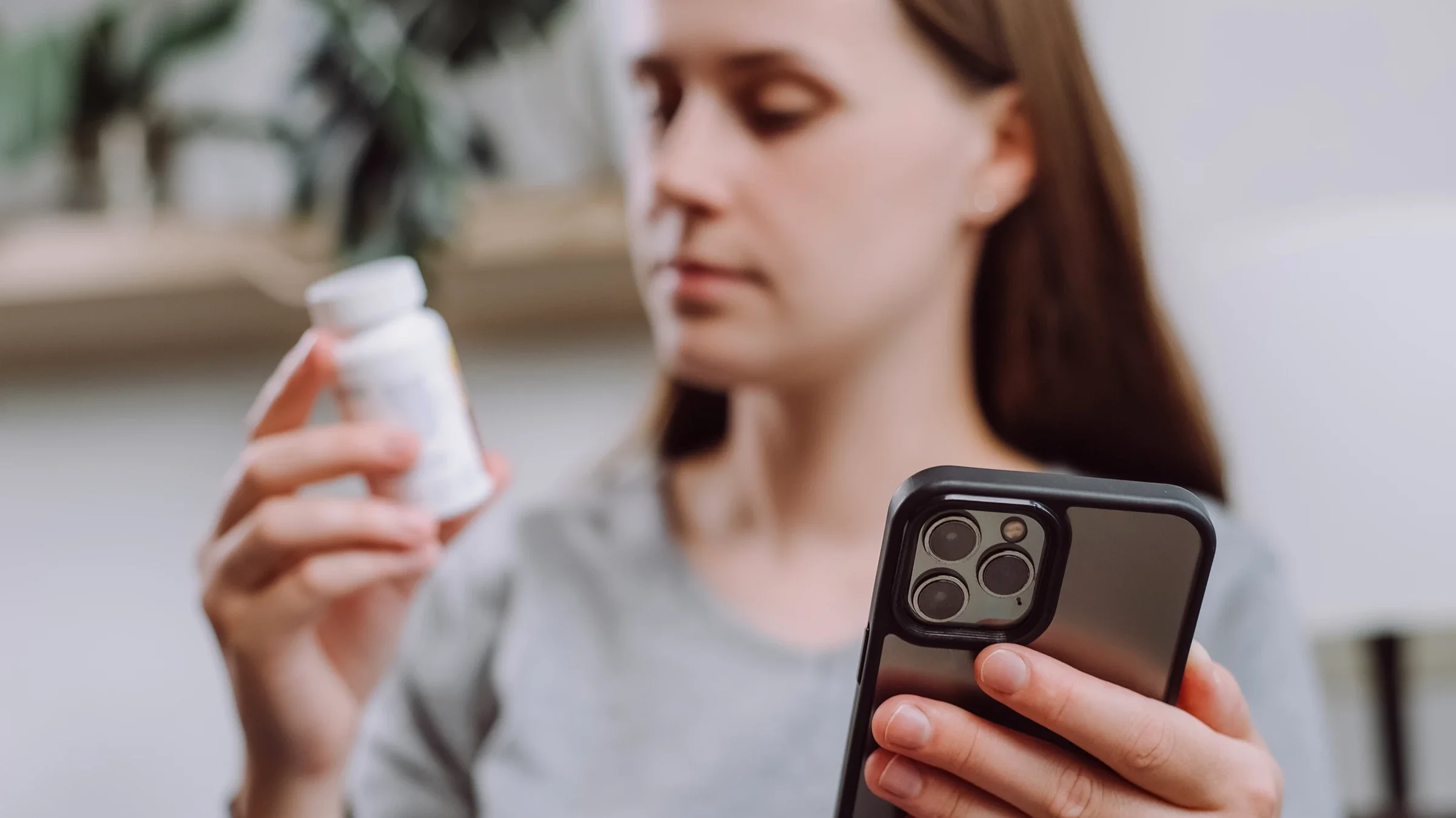 A woman looks up her medication on a smartphone.