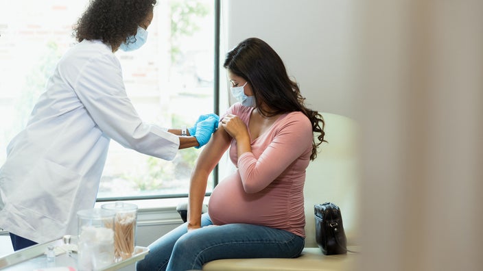 Pregnant woman getting a shot in the doctor's office.