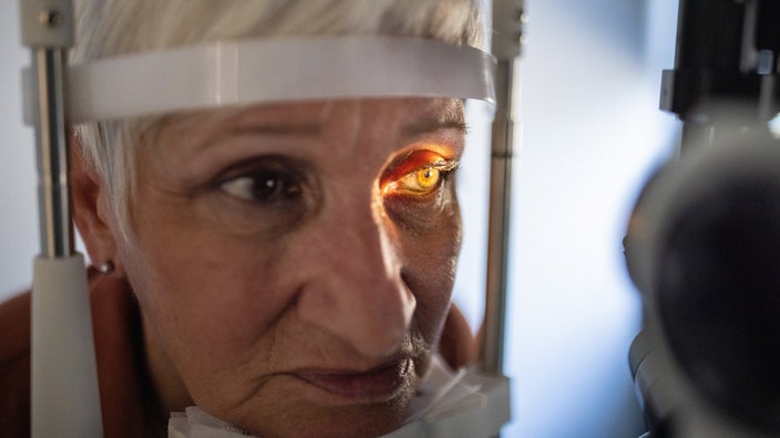 Close-up of an older woman having her eyes examined at the optometrist.