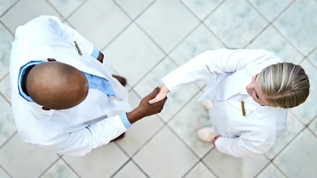 Pharmacists: Valued-based care: hcps shaking hands from above 1068320118