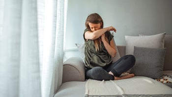 Cough: woman coughing at home 1217033083