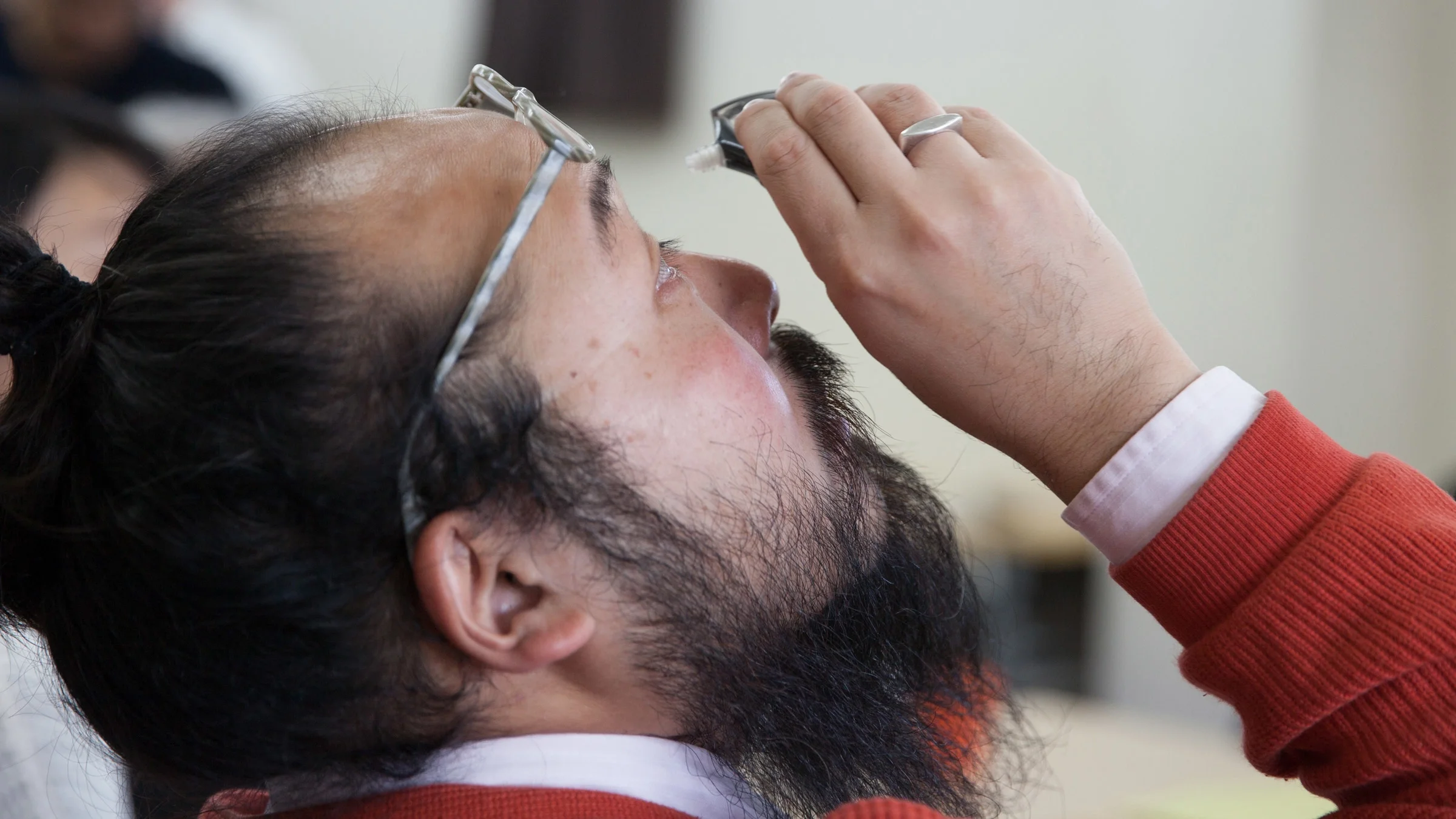 A person using eye drops.