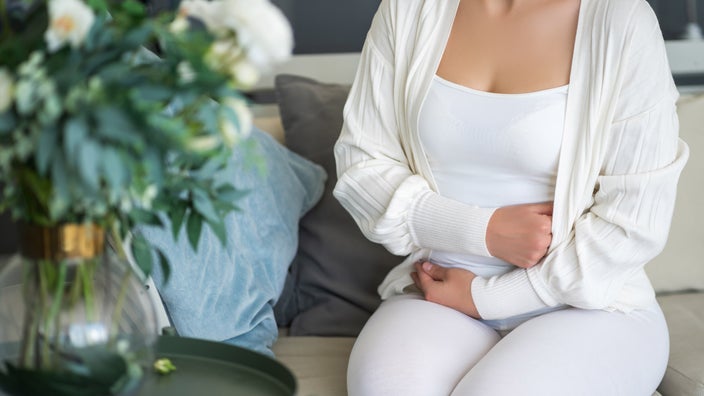 A cropped image of a person experiencing abdominal pain.