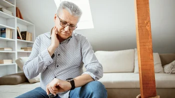 Heart health: senior man taking pulse at home-1310179091