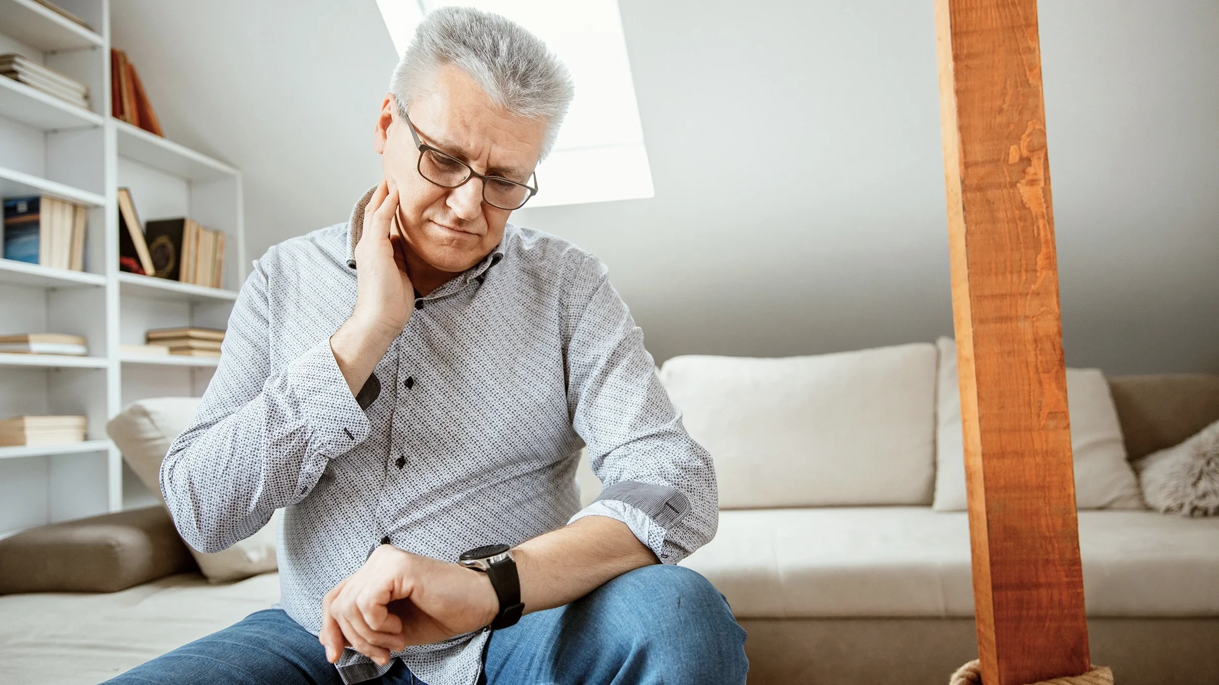 Older adult using his watch to help take his resting heart rate at home.