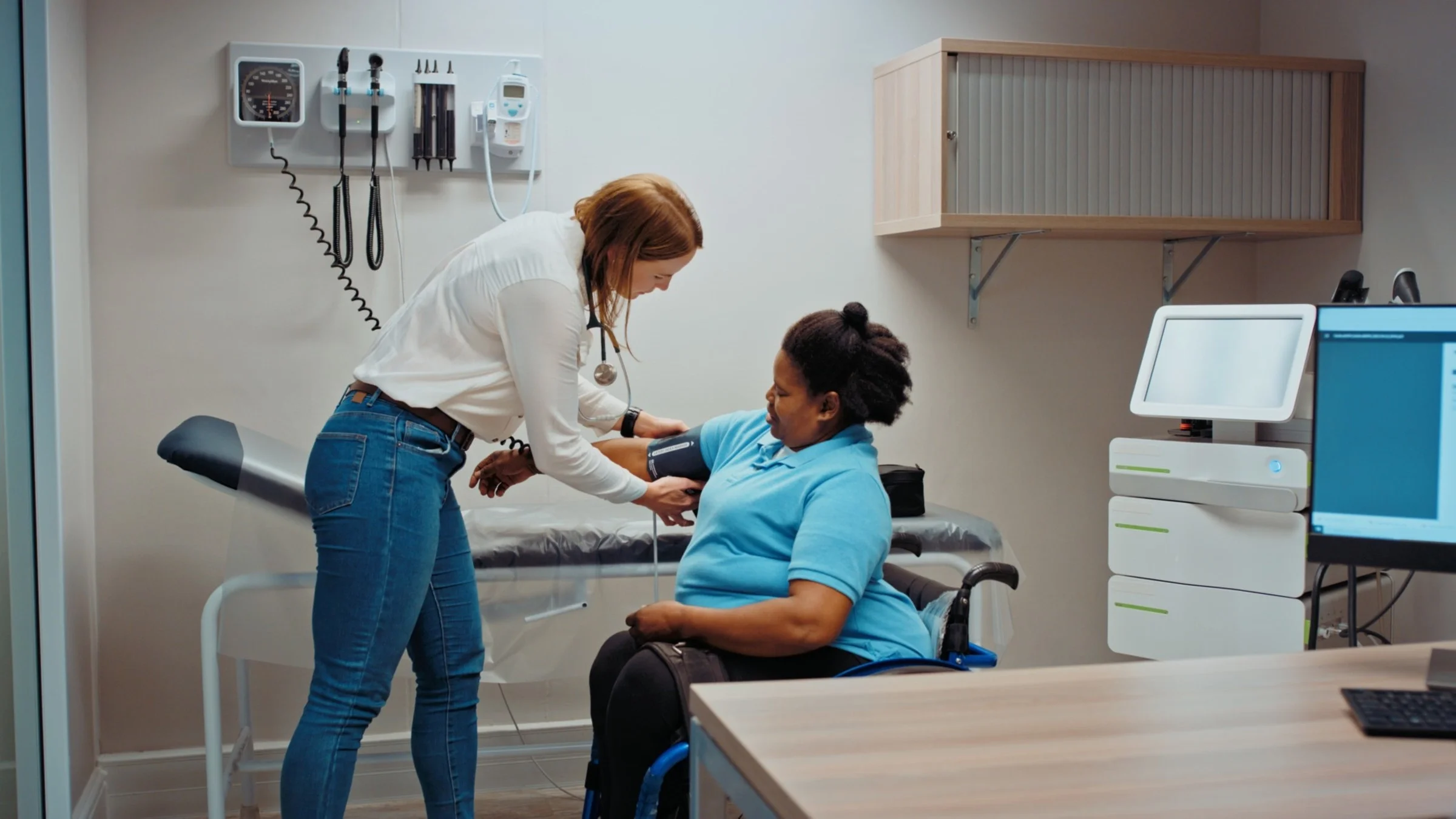 A healthcare professional checks a woman’s blood pressure during a checkup.
