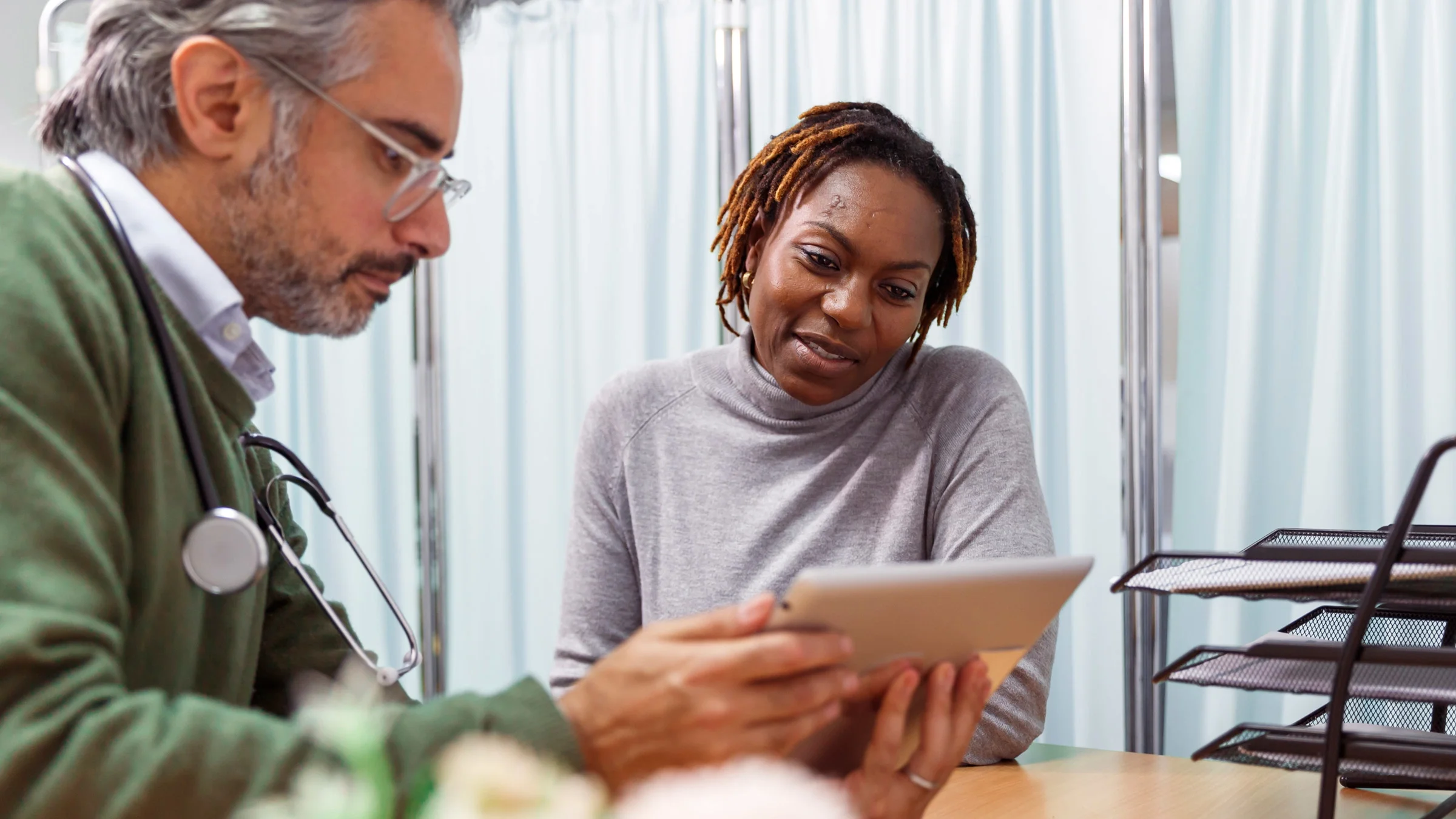 A doctor showing their patient a tablet.