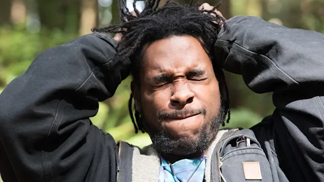 Health: Ear health: man with ringing in ear wincing-471372638