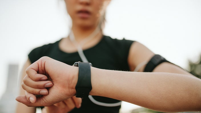 Cropped close-up of a woman using her smart watch on her morning run.