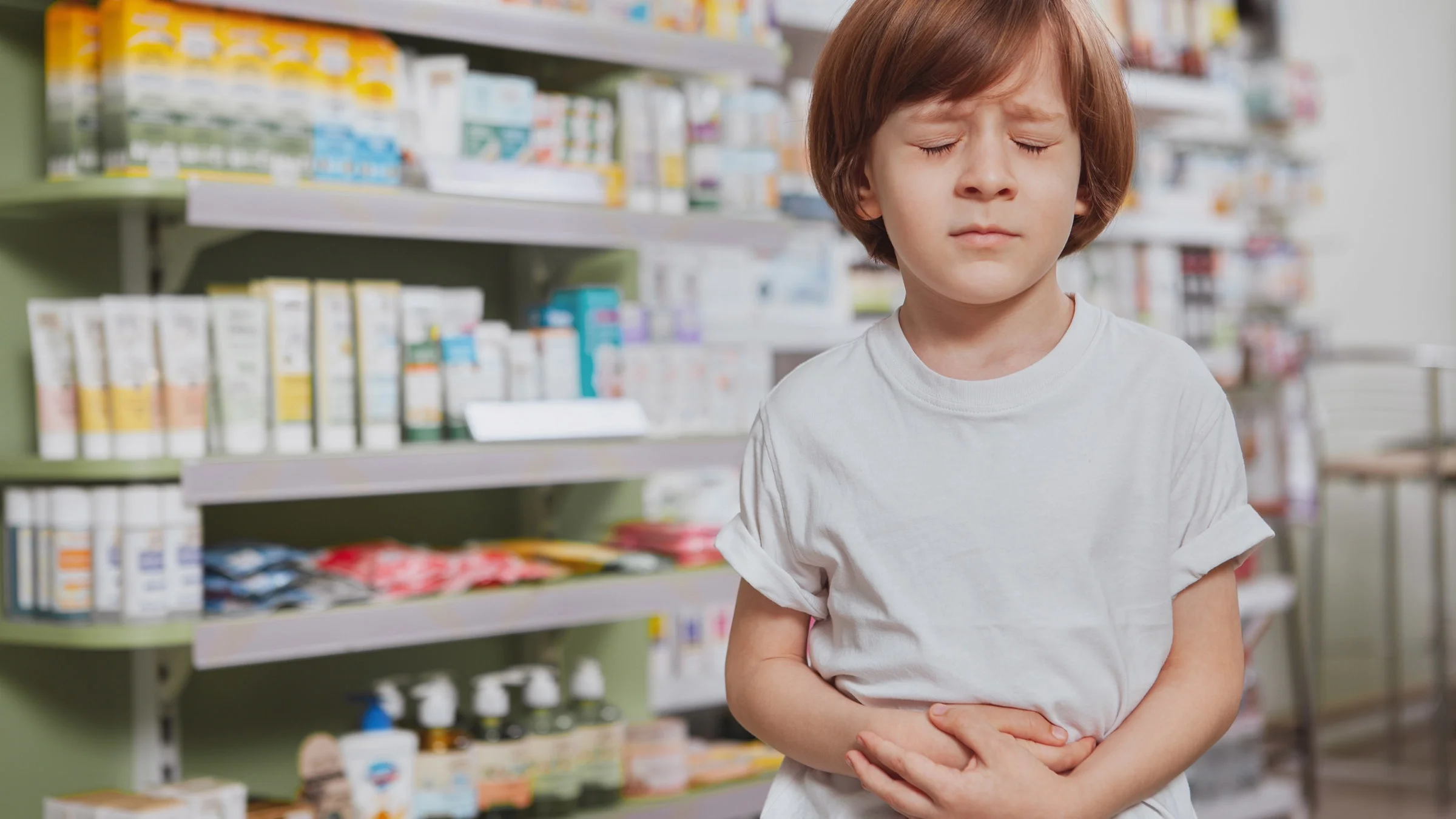 A child with a stomachache in a pharmacy.