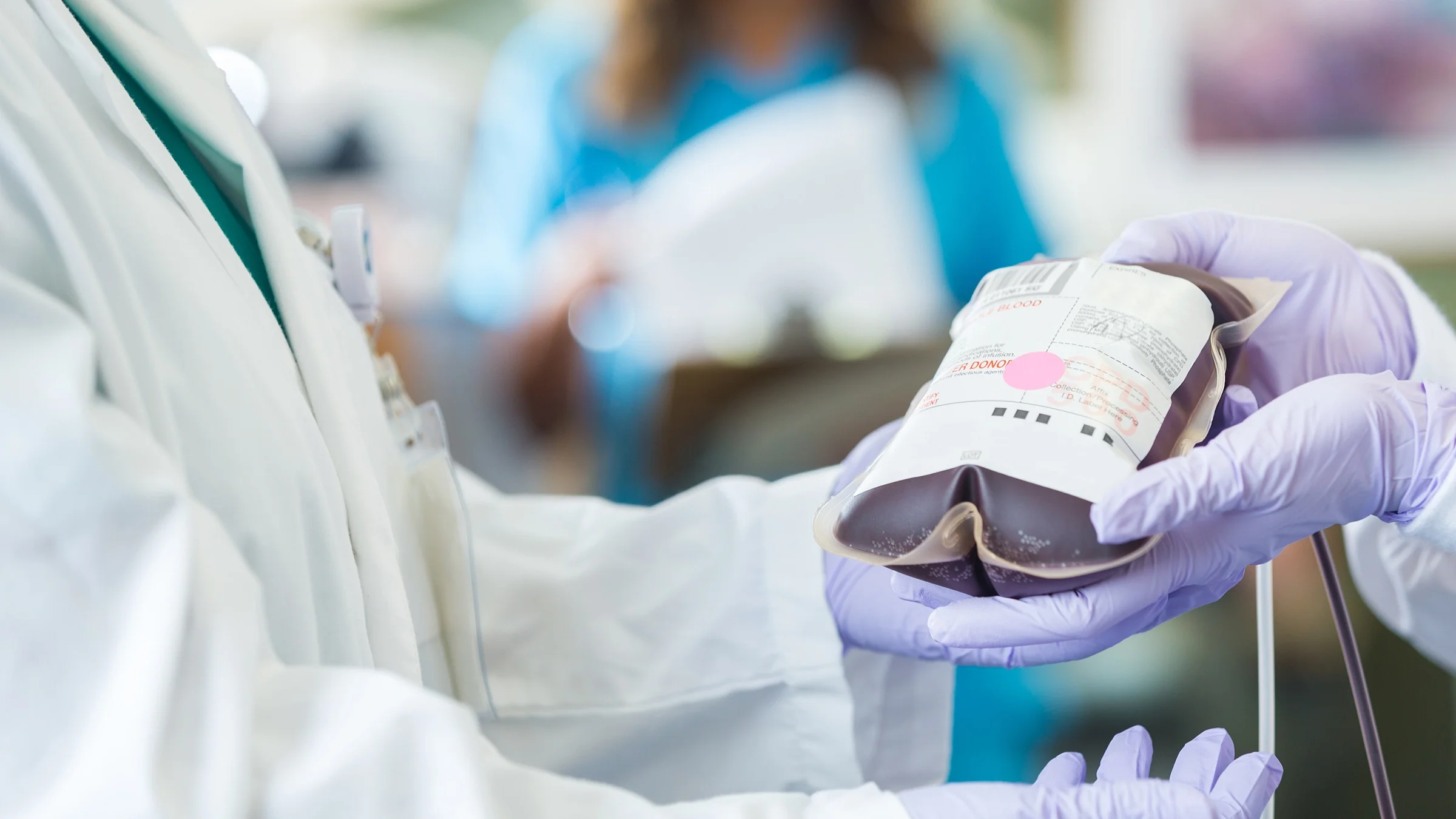 Close-up on a nurse holding a blood bag.