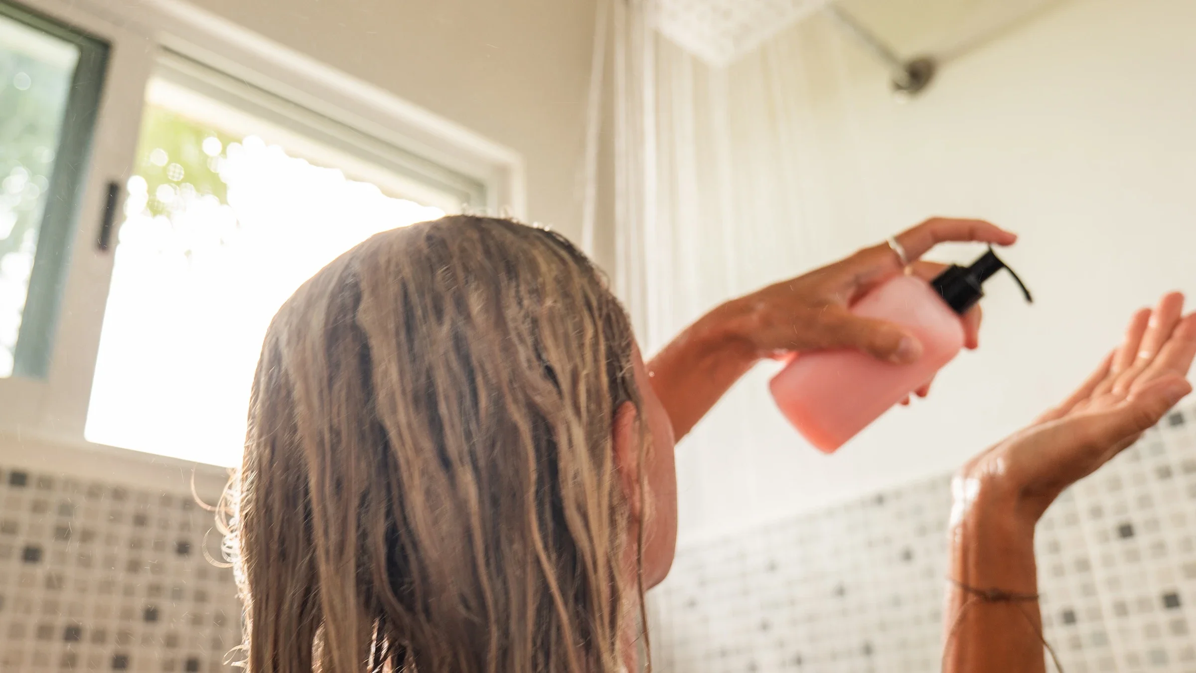 Backview of a woman soaping up in the shower.