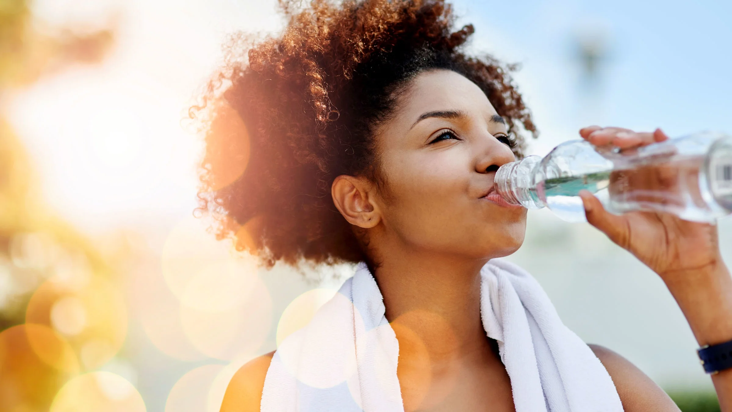 Woman enjoying a bottle of water while out for a run.