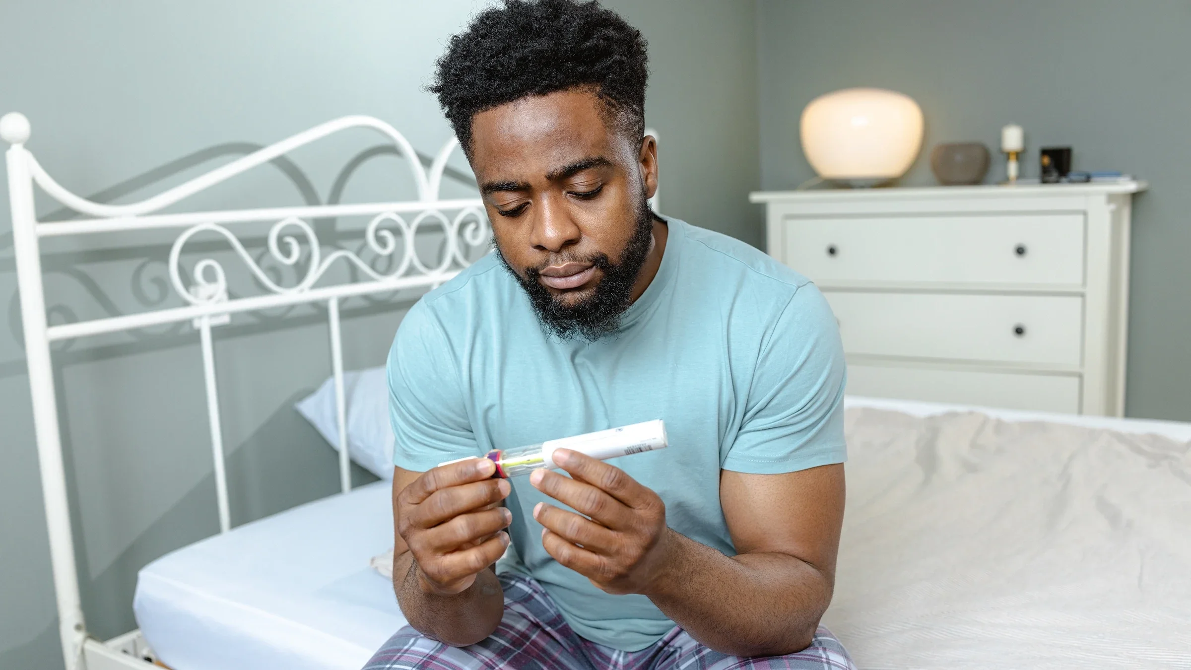 A man is holding a pen injector of Wegovy.