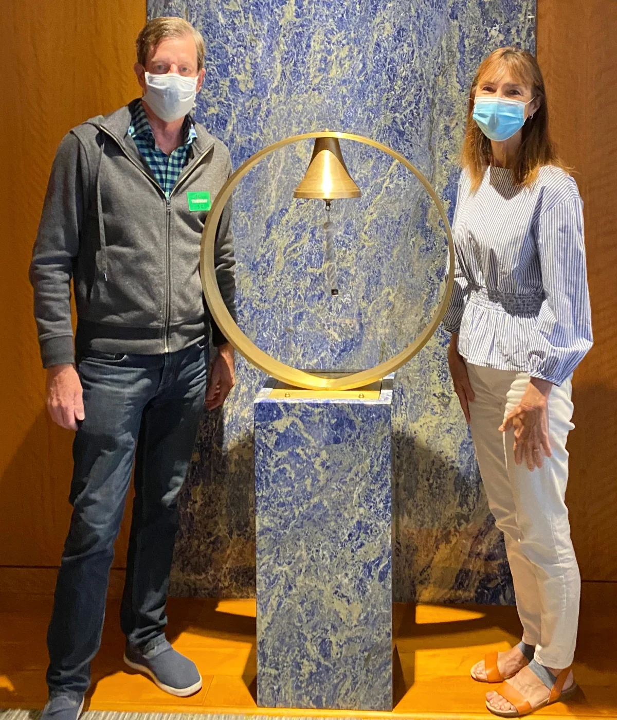 Bill Potts and his wife Kim stand beside a hospital cancer bell, which Bill rang when he was finished with radiation and chemotherapy treatment.