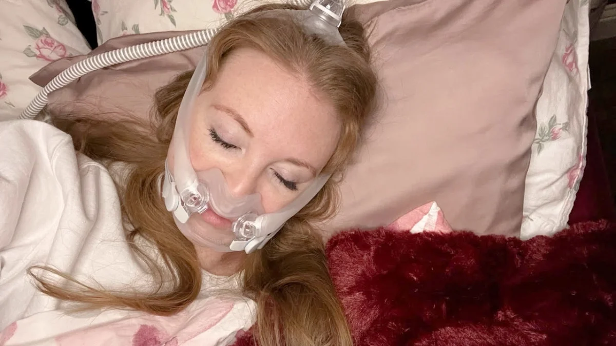 Kajsa Bradley is pictured in bed, wearing her CPAP machine for sleep apnea.