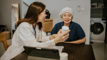Tamoxifen: doctor explaining pill bottle to cancer patient home visit 1364036985