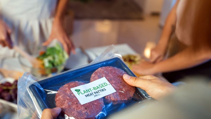Close-up unpacking plant-based meal in kitchen at home.