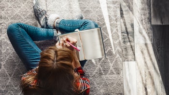 Health: Mental health: overhead shot person writing in journal-1305818842