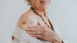 A close-up of a vaccine bandaid on a senior adult's arm.
andreswd/iStock via Getty Images Plus 