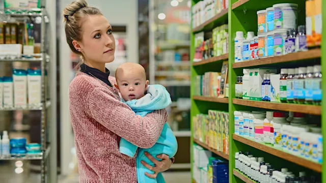 Postpartum depression: Probiotics: holding baby in supplement shop 1068341232