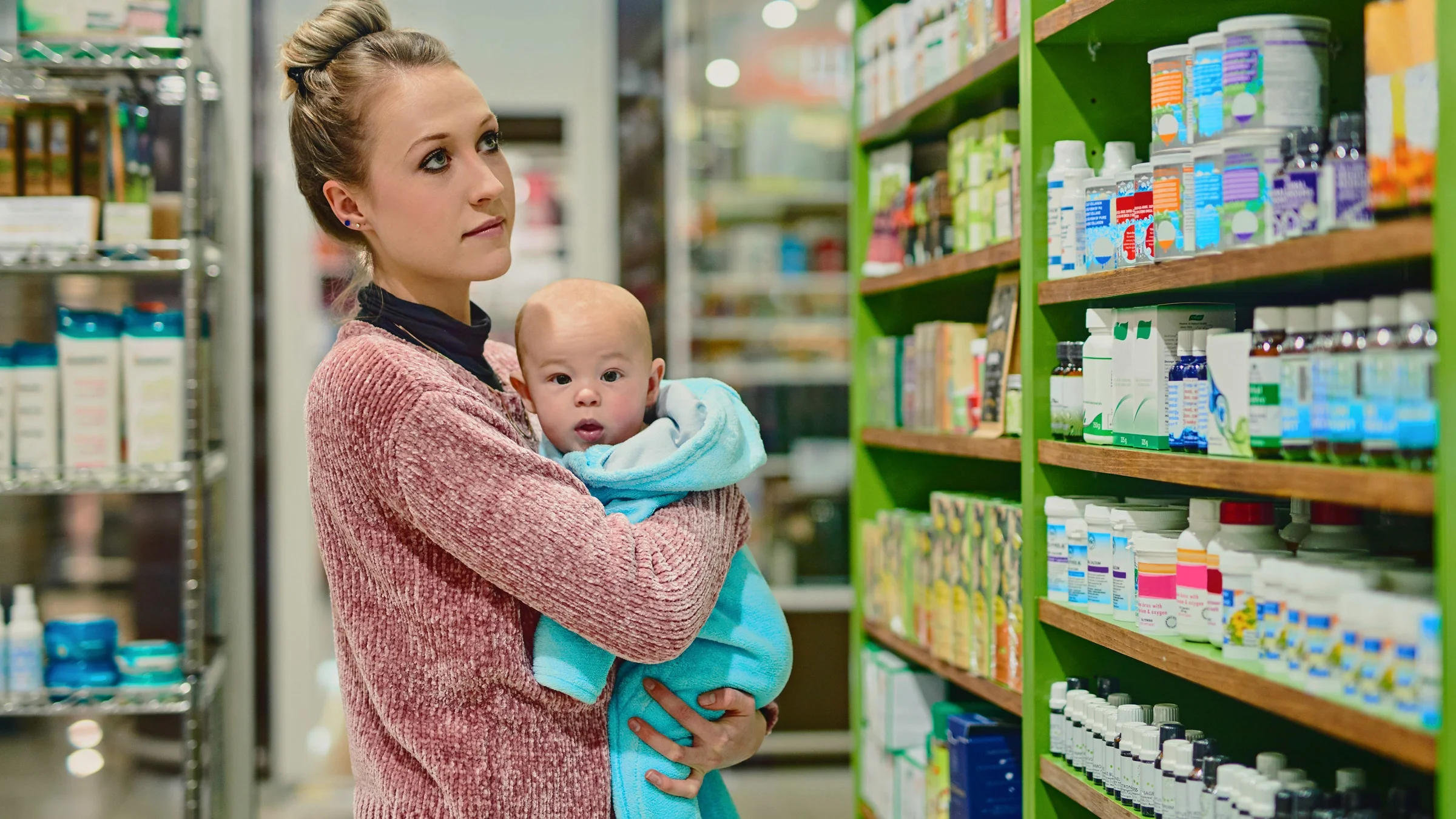 A parent holding a child in a supplement shop.