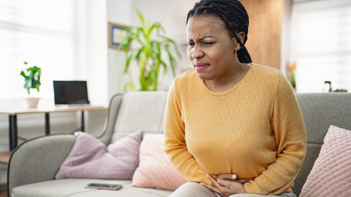 Adult with stomach pain at home.
