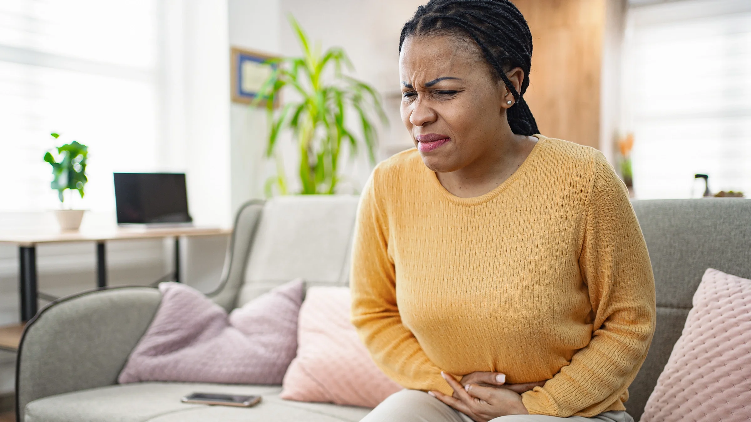 Adult with stomach pain at home.