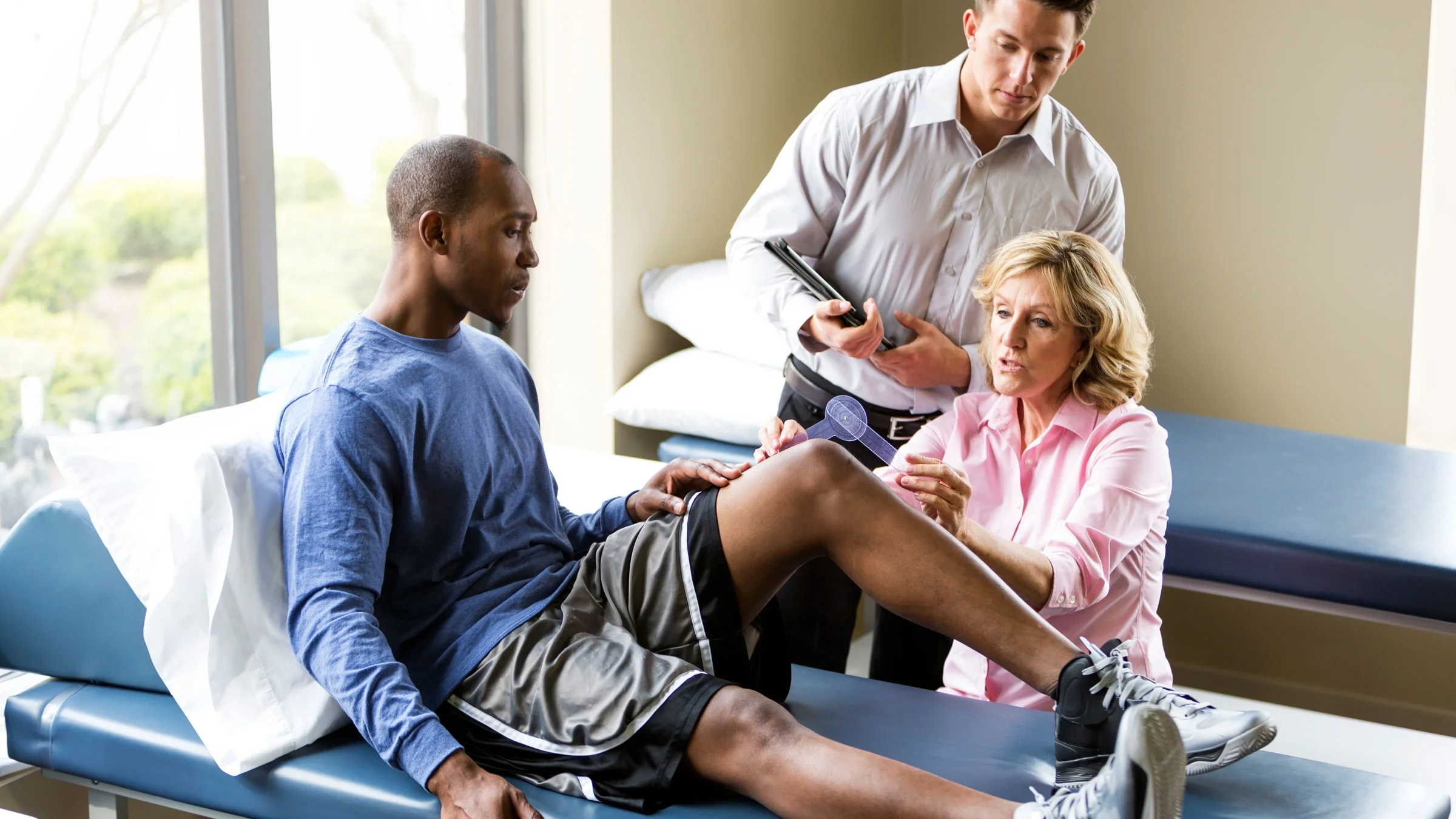 A physical therapist measures a man’s knee with a goniometer. A person’s leg can be longer than the other. But it usually isn’t a problem if the gap is less than 2 cm.