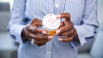 Bidil: cropped hands holding pill bottle 1184031021