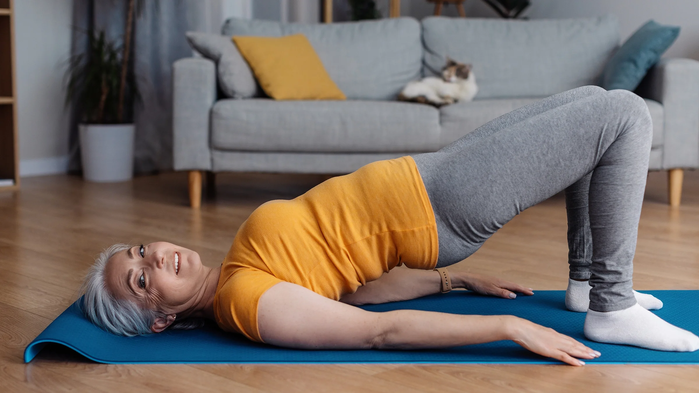 Woman doing bridge exercise on a yoga mat.