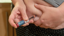 A close-up of someone injecting a syringe into their abdomen.
Vincent Scherert/iStock via Getty Images Plus