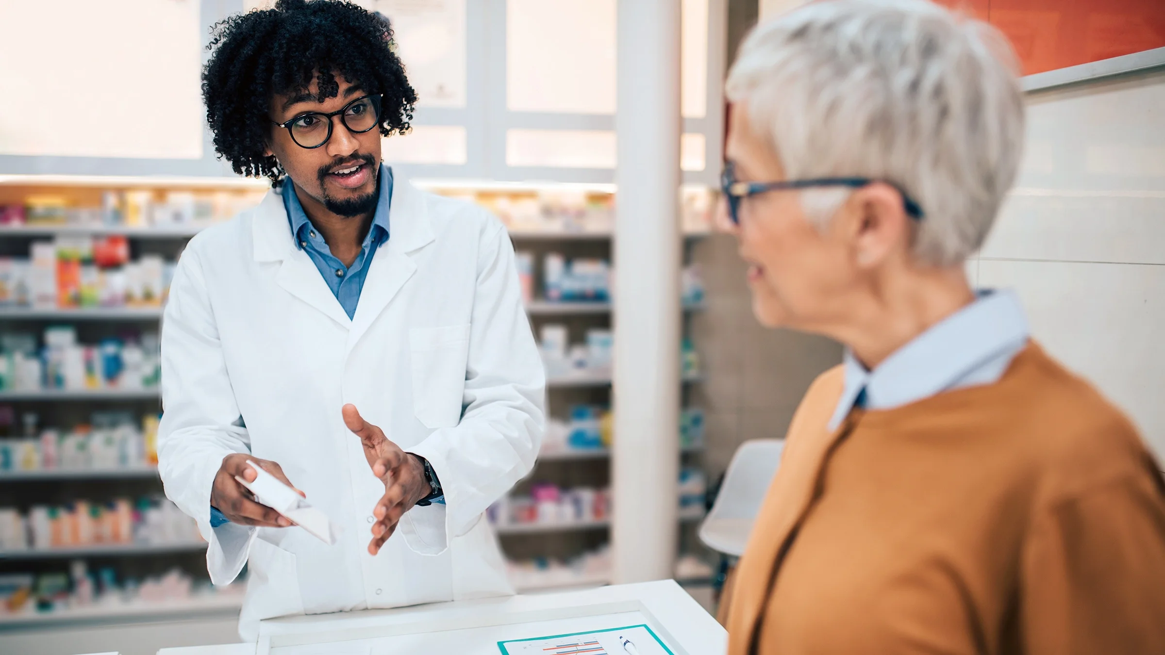 A pharmacist speaks to a customer.