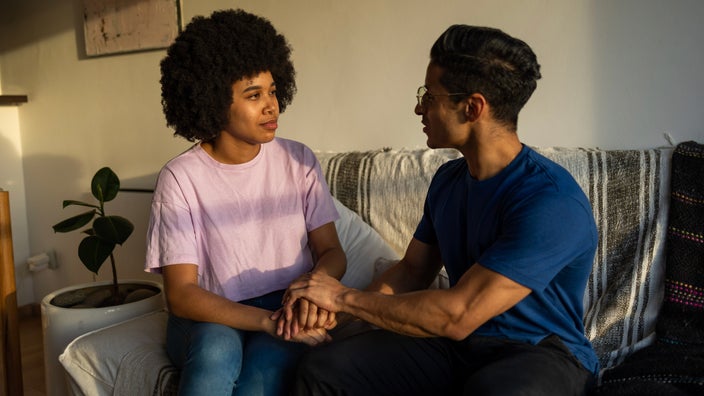 A couple having a difficult conversation on their couch.