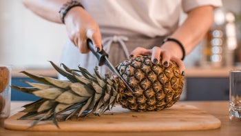 Diet-nutrition: closeup woman cutting pineapple 1456852202