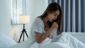 Cough: Cold Symptoms: woman coughing in bed 1369771973