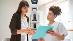 A woman is reviewing test results with a nurse at a mammogram appointment.
izusek/E+ via Getty Images