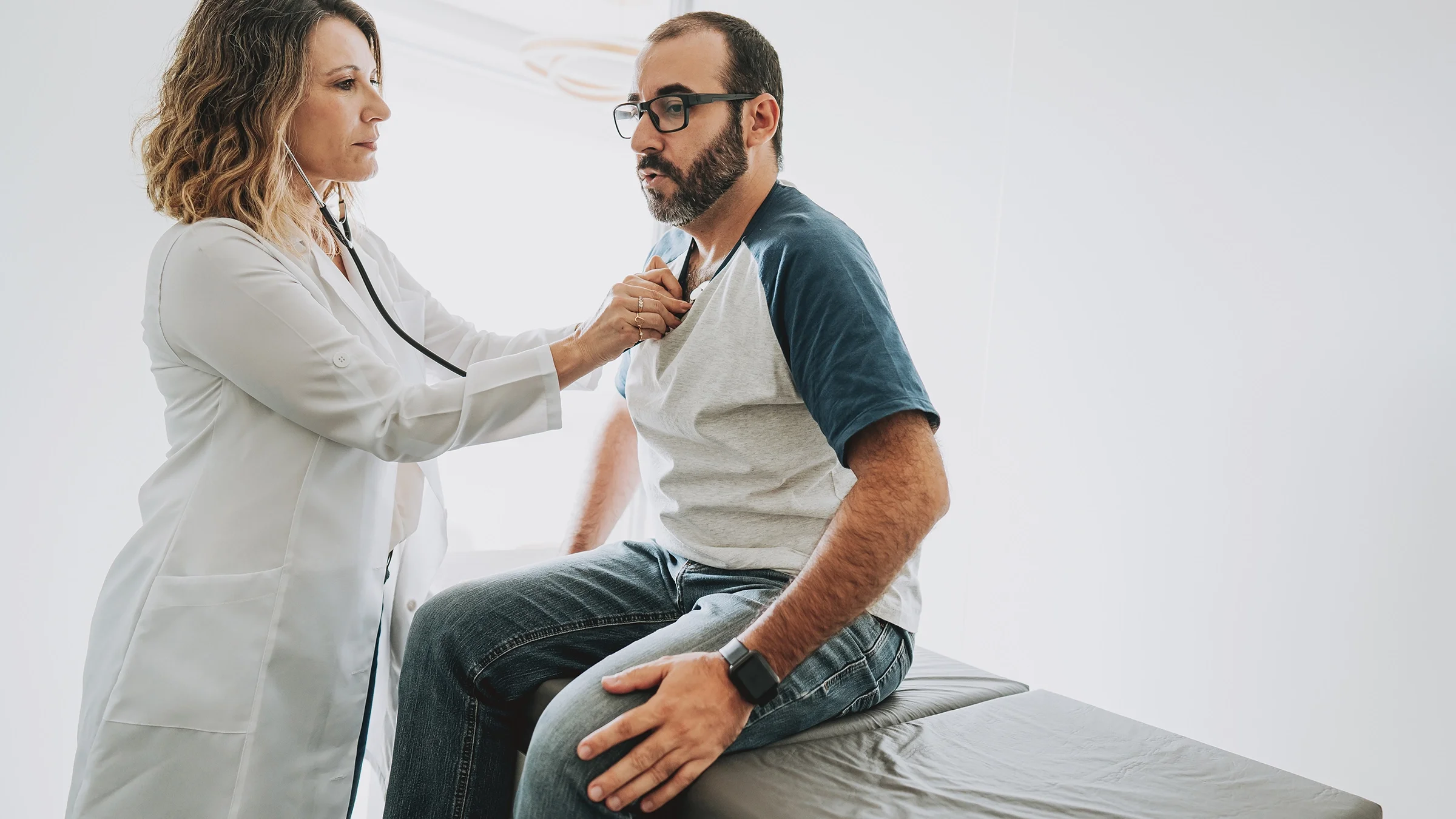 Healthcare professional listening to a patient’s heartbeat.