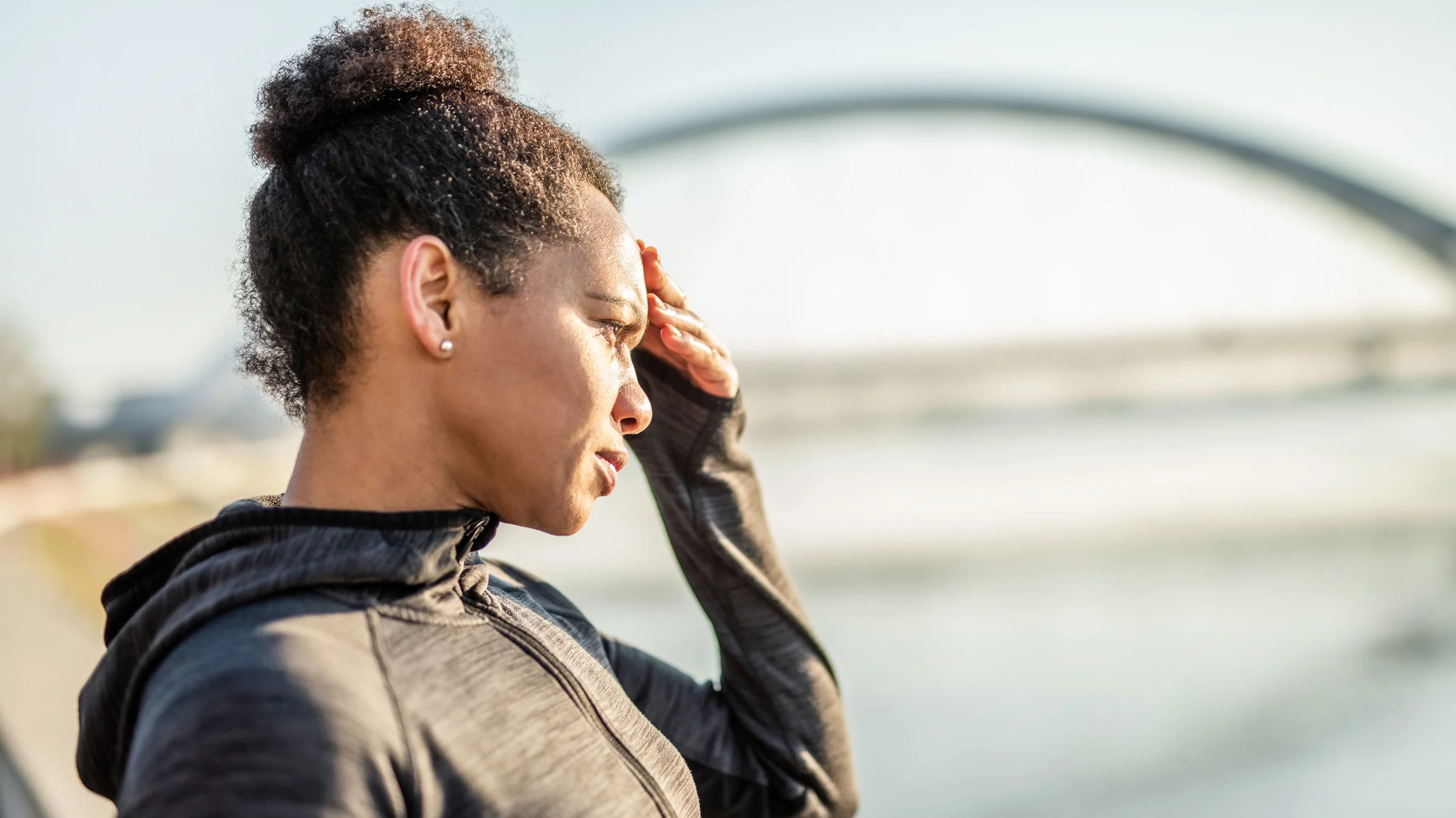 A woman is shown holding her head, like she has a headache, after a workout.