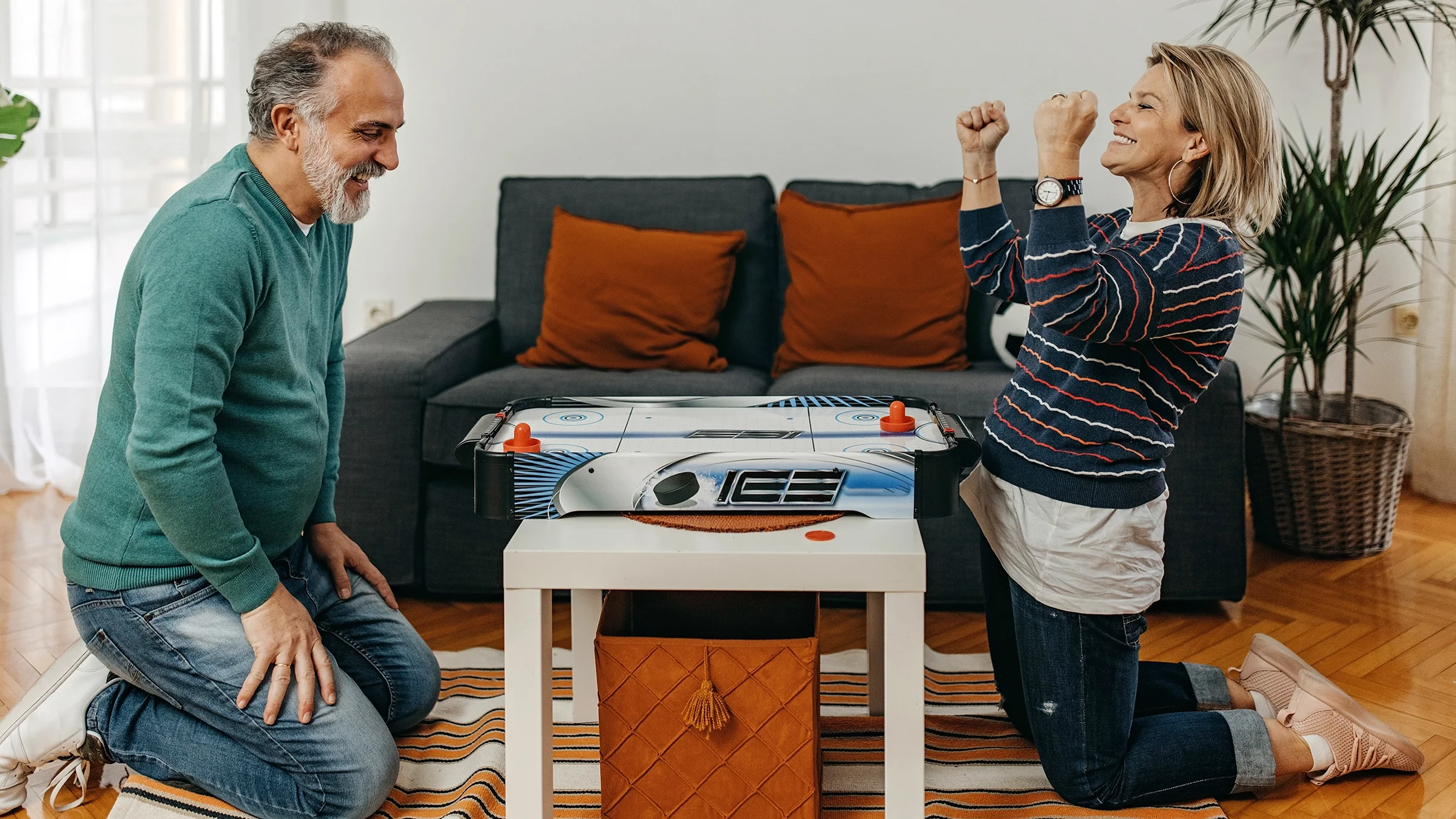 A couple is playing a game at home in their living room.