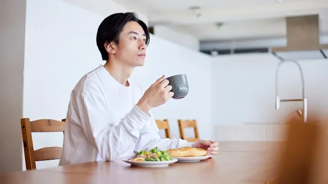 ulcerative colitis: man eating breakfast at home 2101585760