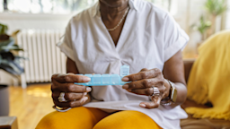 A woman holds her daily pill box.
Fly View Productions/E+ via Getty Images