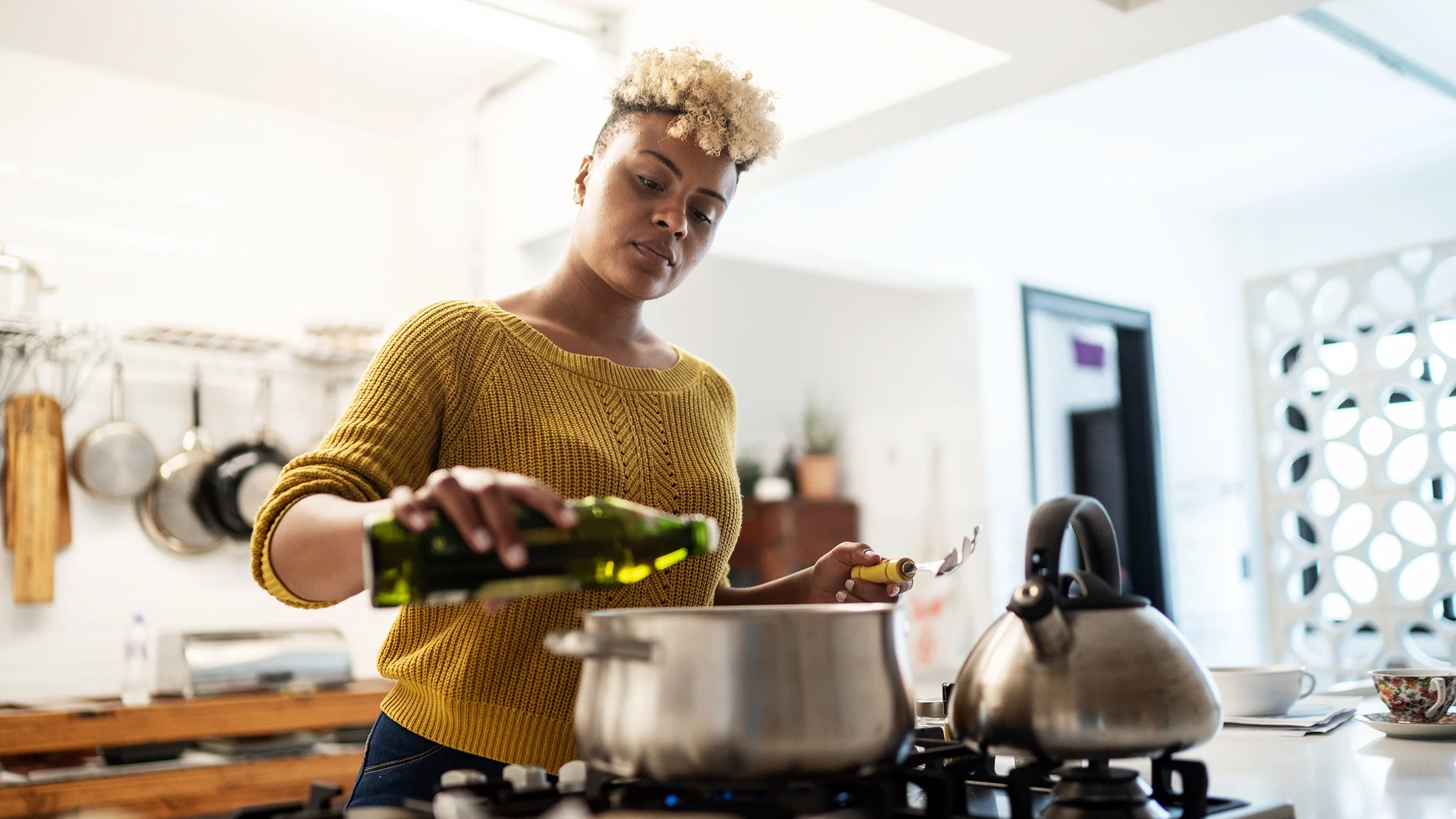 A woman uses olive oil to prepare food. Olive oil is one of the foods that can help lower the risk of blood clotting.