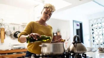 deep vein thrombosis: woman cooking with olive oil 1291246517