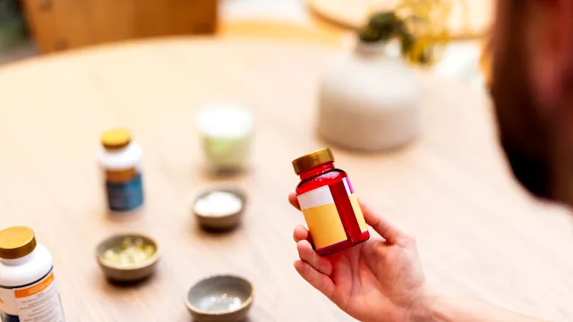 Supplements and Herbs: man holding vitamin bottle 1486468892