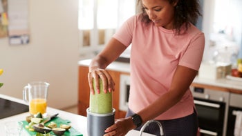 dental care: woman making green smoothie 1162987280